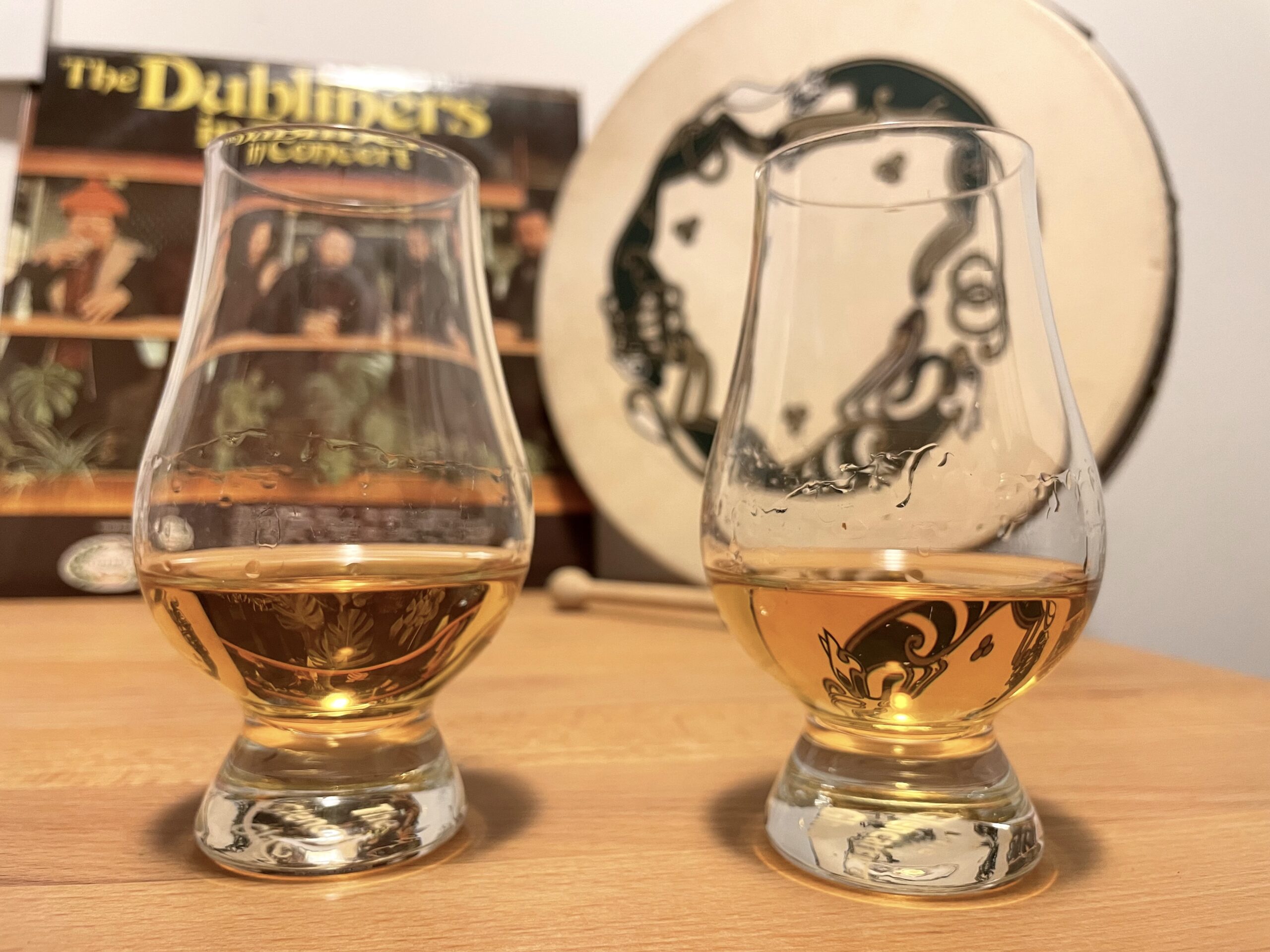 zwei Nosing-Gläser mit Whisky vor einer Dubliners-Platte auf einem Tisch