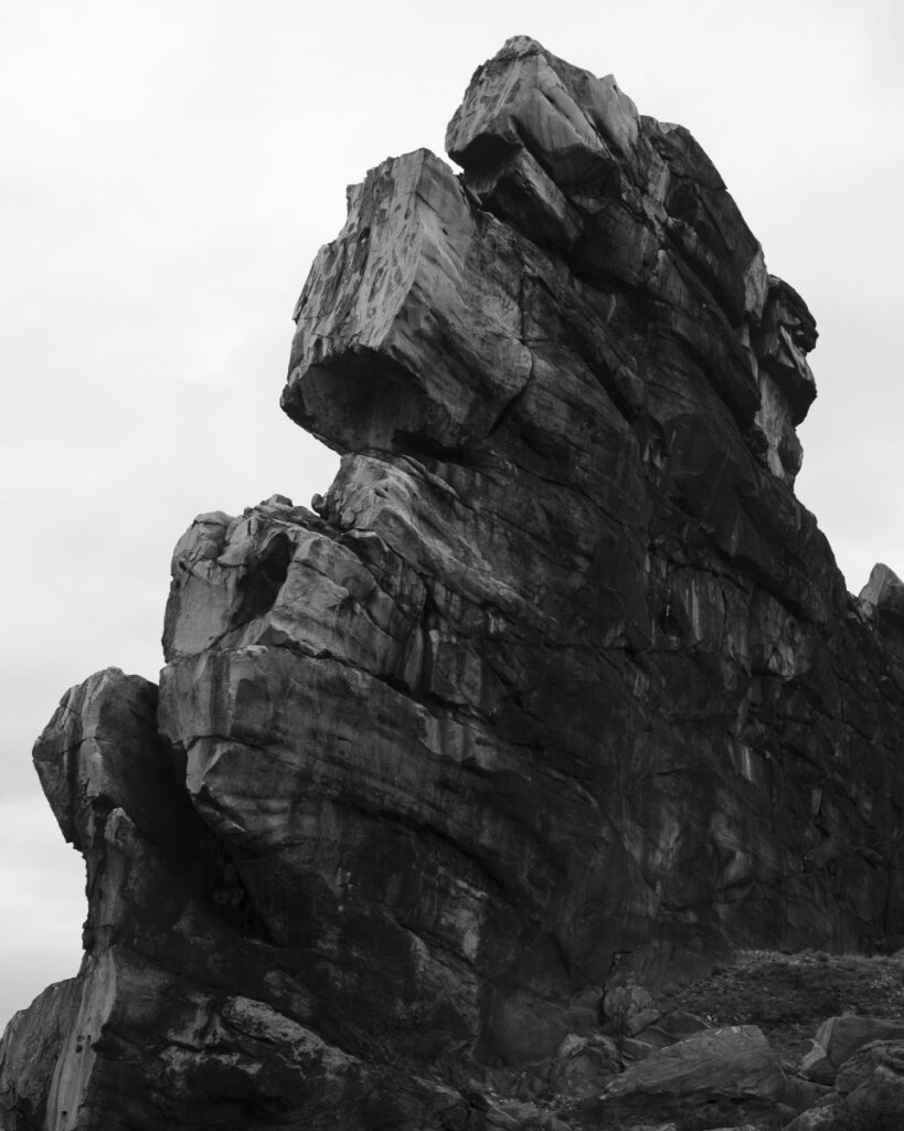 Schwarz-Weiss-Aufnahme von einem verwitterten Felsen.