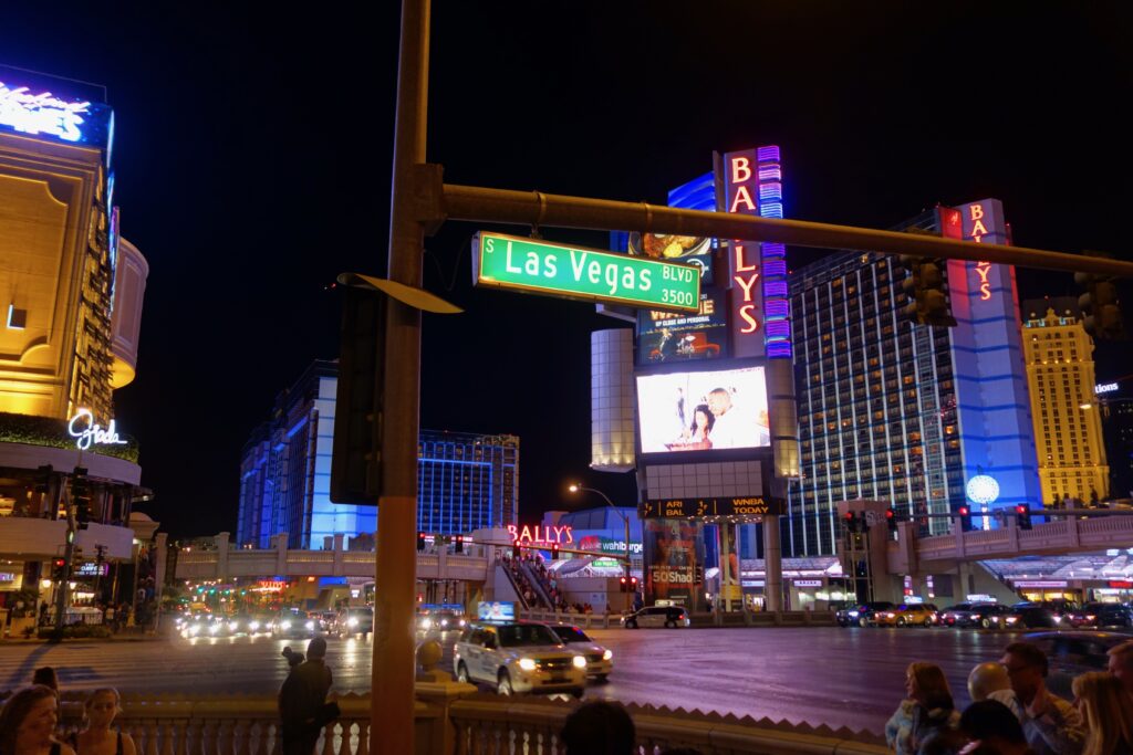 Ansicht des Strip in Las Vegas mit Neonbeleuchtung und leuchtendem Strassenschild