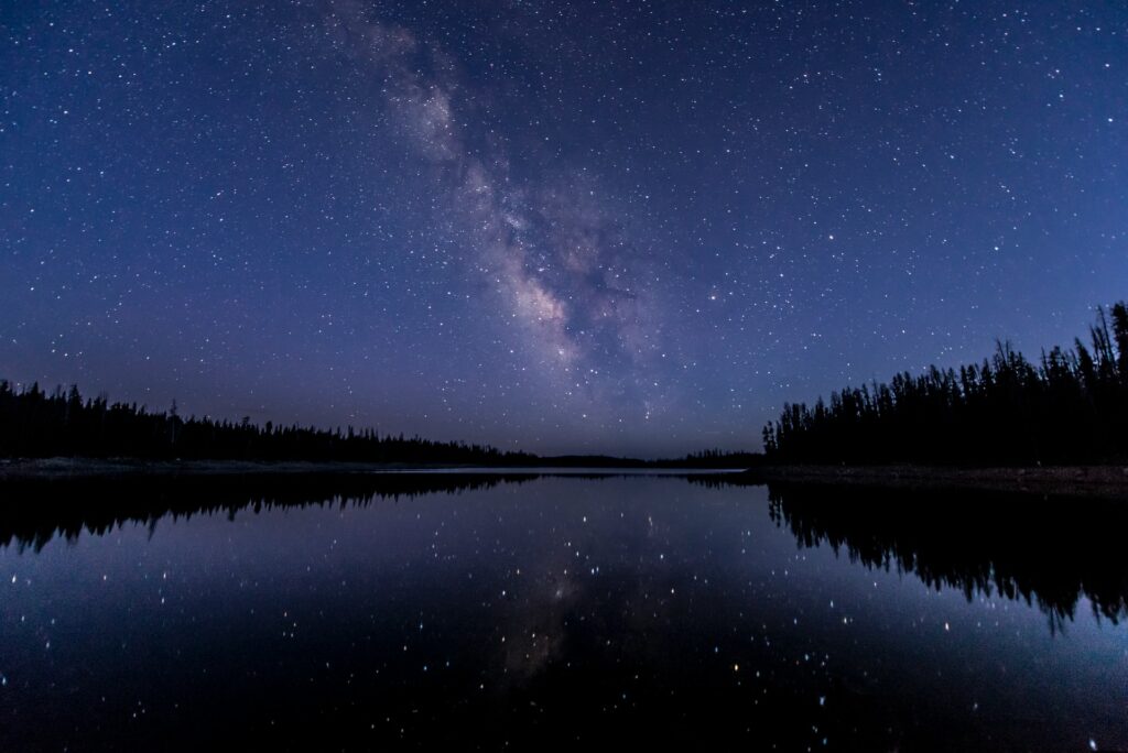 Die Milchstraße und der Sternenhimmel spiegeln sich in einem See