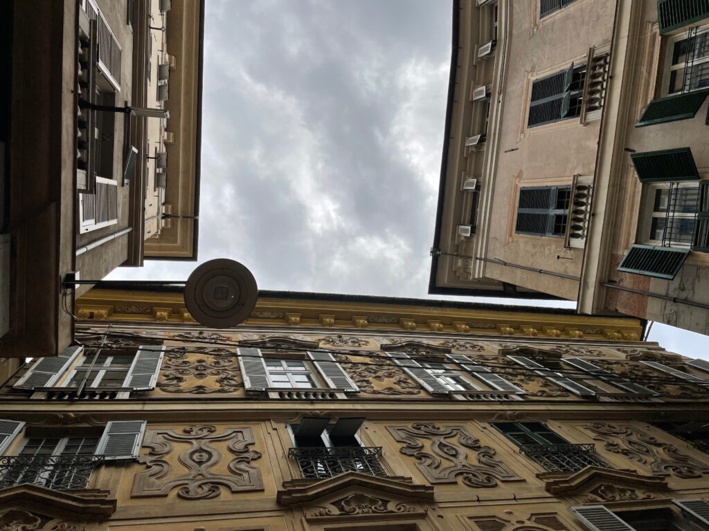 Blick nach oben an eng aneinanderstehende Gebäude in der Altstadt von Genua