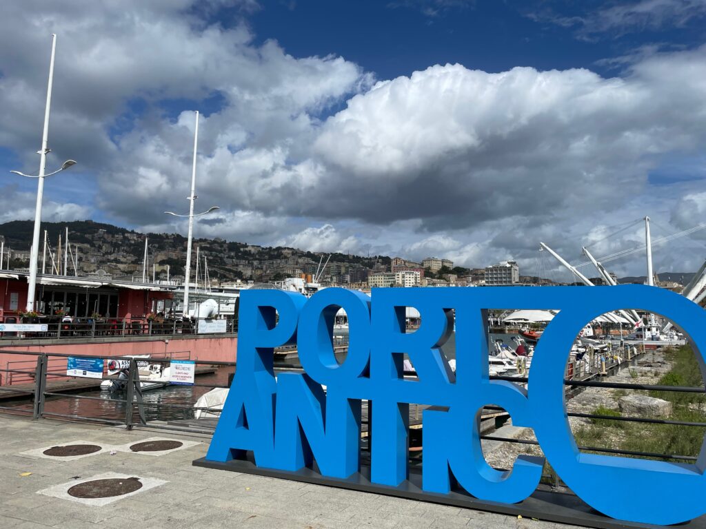 Schriftzug Porto Antico, im Hintergrund der alte Hafen von Genua