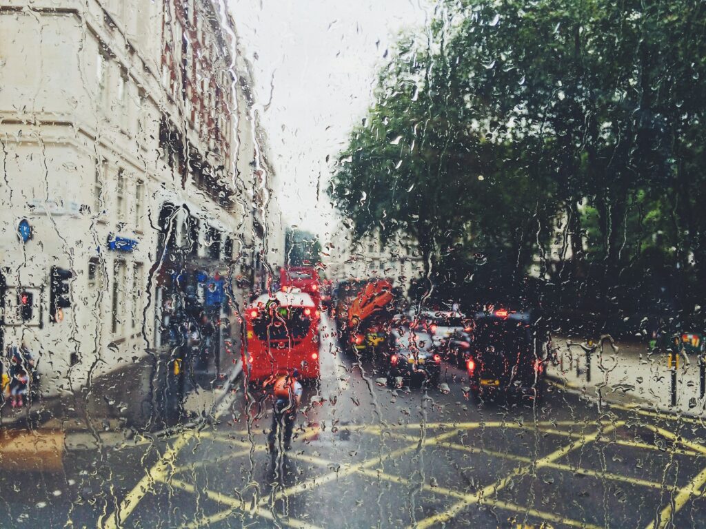 Blick auf eine rege befahrene Straße bei Regen.