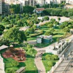Ein Stadtpark mit viel Grün vor Hochhäusern