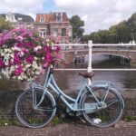 Ein Fahrrad steht an einem Kanal neben einem Blumenkasten