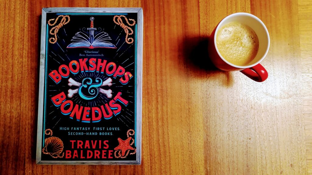 Das Cover von Bookshops and Bonedust neben einer Kaffeetasse